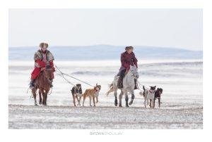 Horsemen and dogs at Competition at Horsemen and hunting dogs at Mongolia's Winter Horse Festival