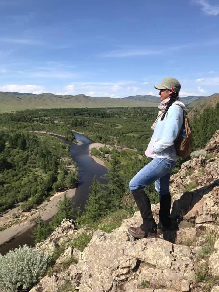 One of our female Mongolian trip assistants is achieving new heights on a trek overlooking a river
