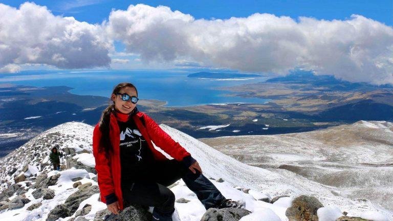 Woman achieving new heights on top of Monkh Saridag Mountain.